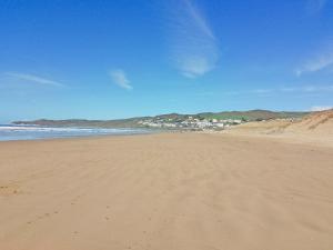 a sandy beach with a town in the distance at Lodge 33 in Woolacombe