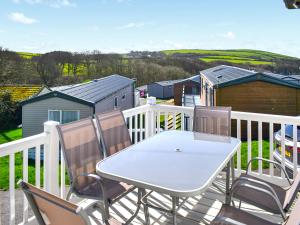 a white table and chairs on a white balcony at Lodge 33 in Woolacombe