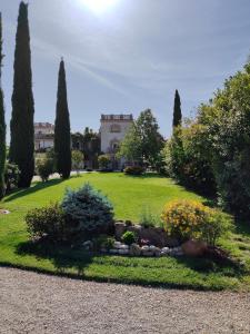 a garden with trees and a house in the background at B&B Galleria 37 in Canosa Sannita