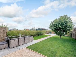 a garden with a lawn and a tree at White Stag Cottage in Bamburgh