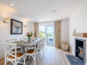 a dining room with a table and chairs and a fireplace at White Stag Cottage in Bamburgh