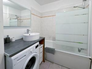 a bathroom with a washing machine and a sink at Le 82 - Studio pour 4 à 3 minutes de Disneyland Paris in Montévrain