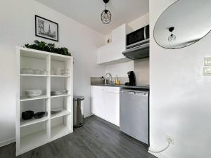 a small kitchen with white cabinets and a dishwasher at Le 82 - Studio pour 4 à 3 minutes de Disneyland Paris in Montévrain