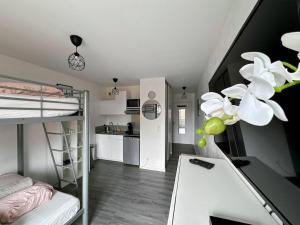 a dorm room with a bunk bed and a kitchen at Le 82 - Studio pour 4 à 3 minutes de Disneyland Paris in Montévrain