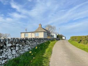 a stone wall in front of a house at Broughton in Newton Stewart