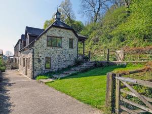 a stone building with a cross on top of it at Clock Cottage in Branscombe