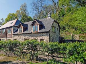 a large stone house with a gambrel roof at Clock Cottage in Branscombe