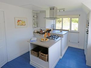 a kitchen with a counter with a stove top oven at Clock Cottage in Branscombe