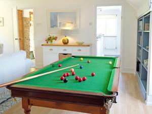 a pool table with balls on it in a living room at Clock Cottage in Branscombe