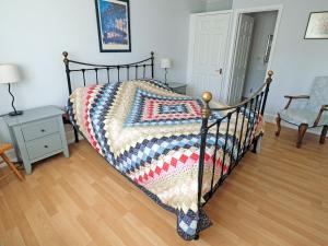a bedroom with a bed with a quilt on it at Clock Cottage in Branscombe +12 photos