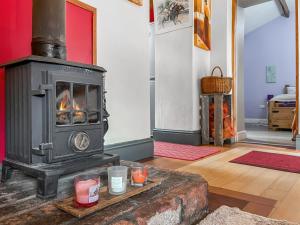 a fireplace in a living room with candles on a table at Silk Hill Stables in Whaley Bridge