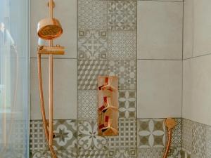 a shower in a bathroom with a tile wall at Honeycott in Crickhowell
