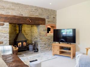 a living room with a stone fireplace and a television at Herrock View in Evenjobb
