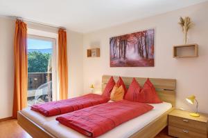 a bedroom with two red pillows on a bed at Rienznerhof Natureplace in Montagna
