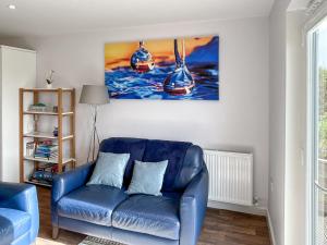 a blue couch in a living room with a painting on the wall at Wisteria Lodge - Uk51605 in Peel