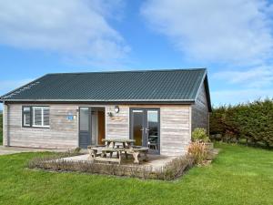 a small house with a picnic table in the yard at Wisteria Lodge - Uk51605 in Peel