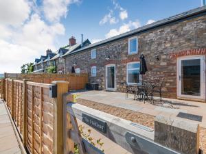 a patio in front of a brick building at The Stables - Cottage in Raglan