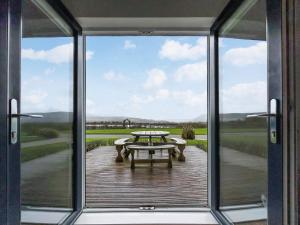 a view from the door of a patio with a picnic table at Primrose Lodge - Uk51602 in Peel