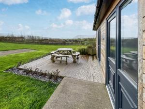 a patio with a picnic table next to a window at Primrose Lodge - Uk51602 in Peel
