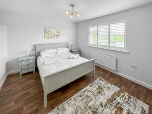 a white bedroom with a bed and a window at Primrose Lodge - Uk51602 in Peel