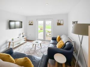 a living room with a couch and a table at Primrose Lodge - Uk51602 in Peel +8 photos