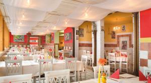a dining room with white tables and white chairs at Kinderhotel Appelhof in Mürzsteg