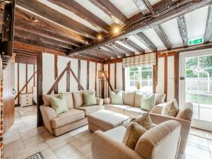 a living room with couches and chairs and windows at The Cottage in Broomfield