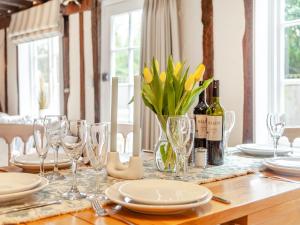 a table with glasses and a bottle of wine and flowers at The Cottage in Broomfield