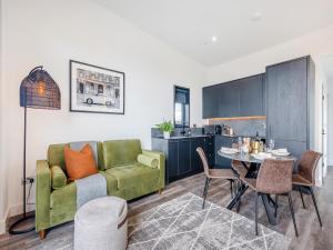 a living room with a green couch and a table at Lligwy Lodge 3 - Uk42793 in Llangefni