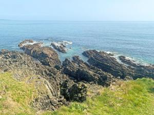 a view of the ocean from a cliff at Spruce Cottage in Tywardreath