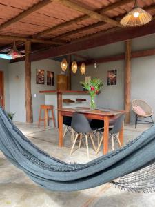 a hammock in a living room with a table and chairs at Pousada Mandala em frente a Praia da Concha in Itacaré