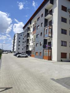 a building with cars parked in front of it at Apartament b&b Rădăuți in Rădăuţi