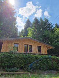 a wooden house with the sun in the background at Chalet De La Forêt - 6 personnes in Saint-Sauveur
