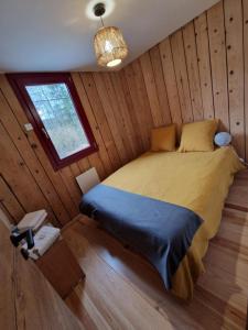 a bedroom with a bed in a wooden cabin at Chalet De La Forêt - 6 personnes in Saint-Sauveur +10 photos