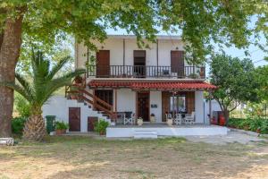 a white house with a balcony and a tree at Eudokia's House Platanias in Platanias