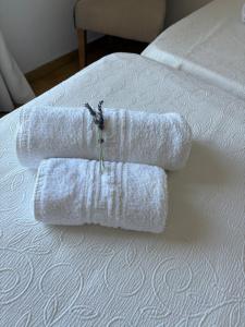 a group of towels sitting on top of a bed at Evangelia Studios in Sígrion