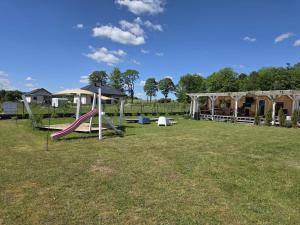 a playground with a slide and an umbrella at Chatka u Radka in Radacz +18 photos