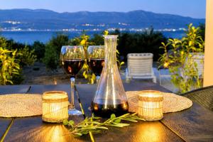 two glasses of wine sitting on a wooden table at Olive Garden Home with Jacuzzi and Privacy in Mirce +20 photos