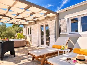a patio with awning and a table and chairs at Olive Garden Home with Jacuzzi and Privacy in Mirce