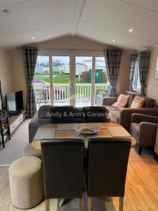 a living room with a couch and a table with chairs at 273 Northfield in Skipsea