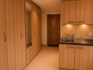 a kitchen with wooden cabinets and a sink at Chalet Nunavut, Ski in - Ski out with Complimentary Spa Access in Zermatt