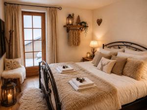 a bedroom with a large bed with towels on it at Chalet Nunavut, Ski in - Ski out with Complimentary Spa Access in Zermatt