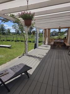 a wooden deck with a pergola with a plant at Chatka u Radka in Radacz