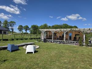 a pavilion with chairs and a table in a field at Chatka u Radka in Radacz
