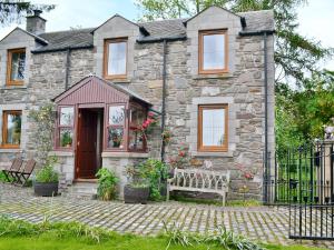 a stone house with a bench in front of it at Buchanan's Bothy in Glencarse