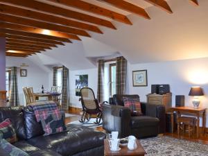a living room with a leather couch and chairs at Buchanan's Bothy in Glencarse