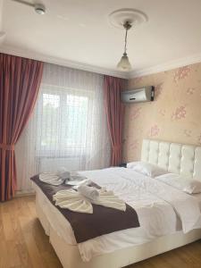 a bedroom with a large white bed with red curtains at Kiraz Otel in Lapseki