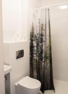 a bathroom with a toilet and a shower curtain at Dom Jogi Studzieniec in Studzieniec