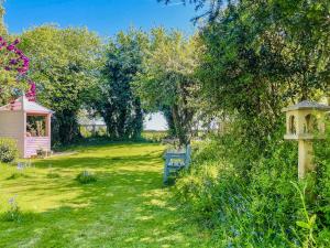 a garden with a blue bench in the grass at Amphlett Cottage in Bredon
