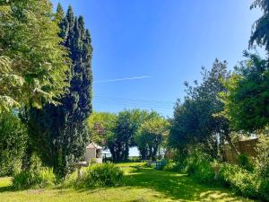 a green yard with trees and a blue sky at Amphlett Cottage in Bredon
